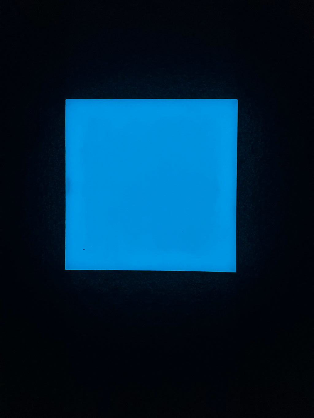 Blue illuminated glow-in-the-dark ceramic tile at night