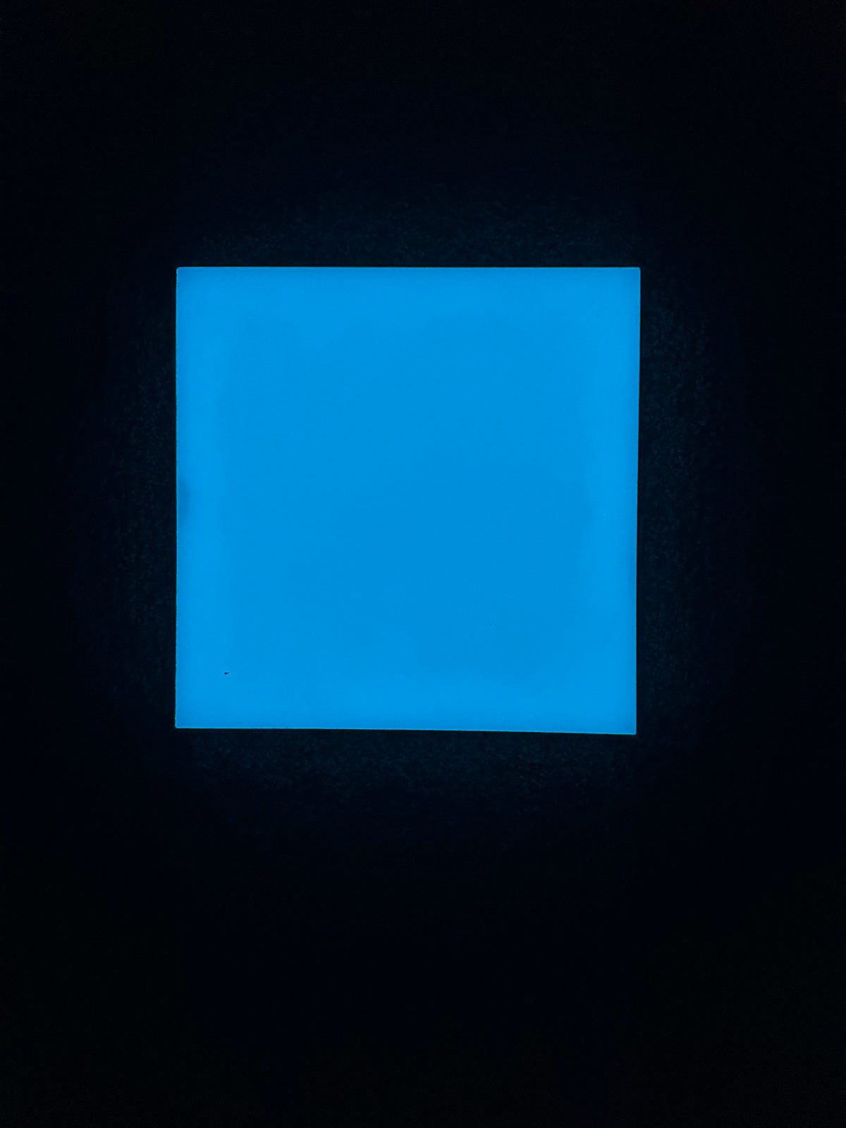 Blue illuminated glow-in-the-dark ceramic tile at night
